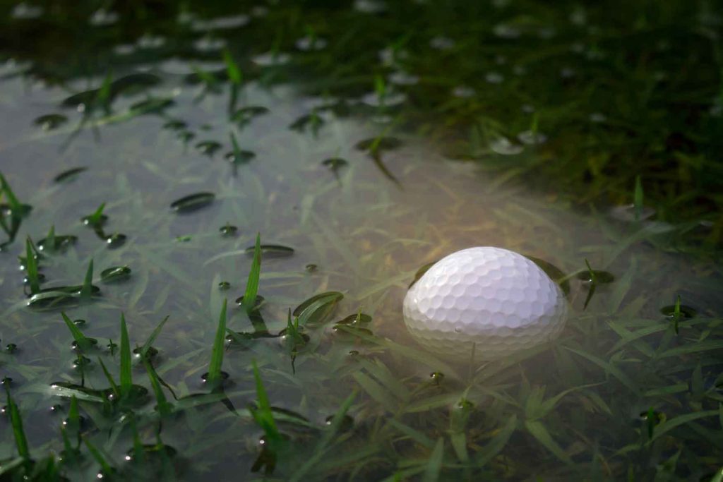 golf ball stuck in a wet puddle
